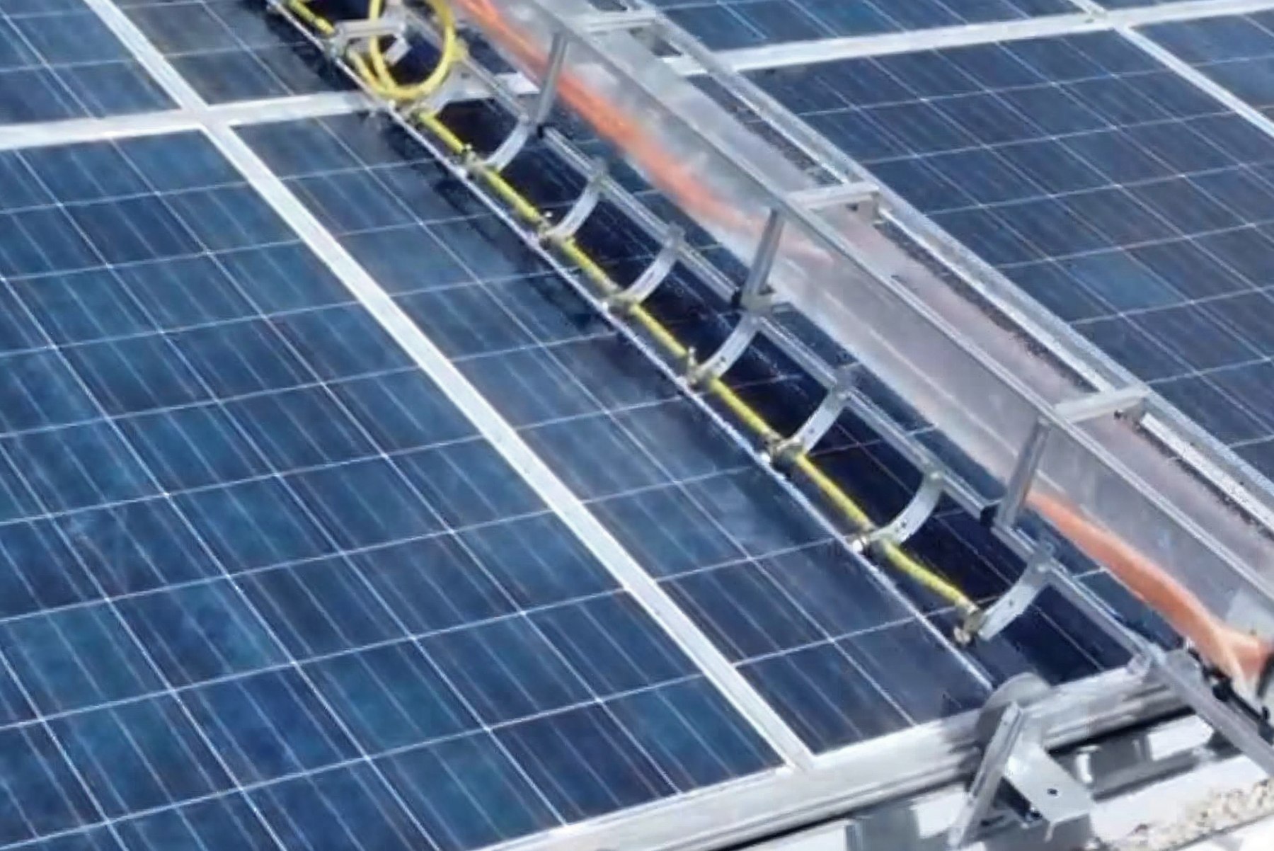 HydroNova robot washing a real panel row with its water nozzle bar